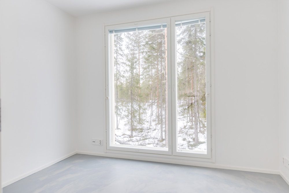Muuttovalmis omakotitalo Oulu: Makuuhuoneen isot ikkunat tuovat valoa sisään. Lattiassa on polyuretaanipinnoite.