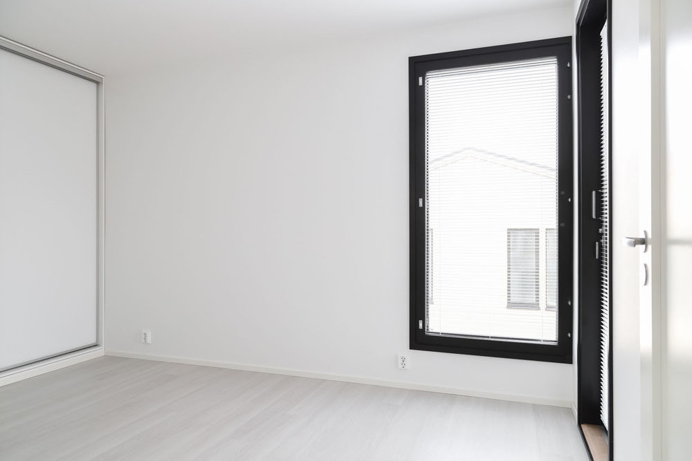 Kaksikerroksinen talo: Mustat ikkunat antavat ilmeen vaaleille makuuhuoneille.