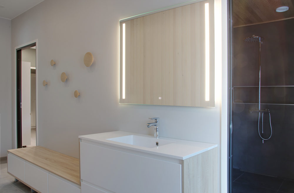 Pukuhuone: Pukeutumishuoneessa vaalean sisustuspaneelin aaltoileva pinta pehmentää niin akustiikkaa kuin sisustusta.