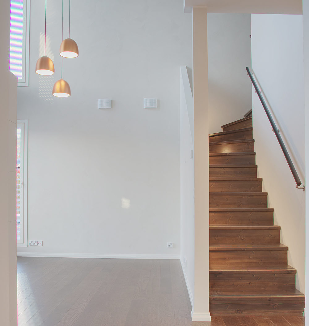 Kaksikerroksinen omakotitalo: Yläkertaan johtavat portaat, jonka askelmat on käsitelty parketin sävyiseksi.