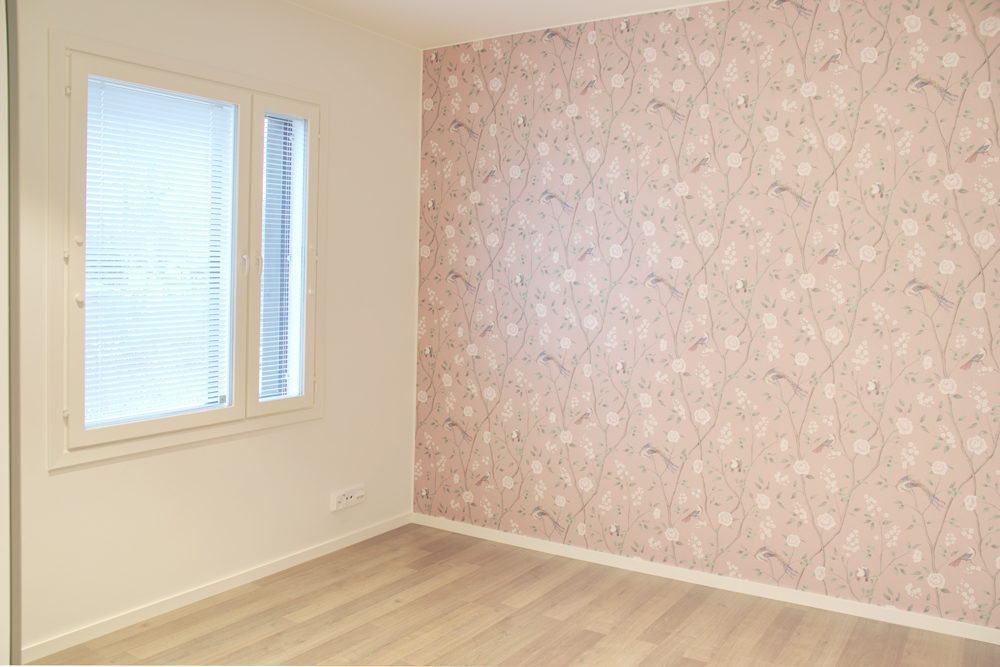 Makuuhuoneen seinässä vaaleanpunainen tehostetapetti.