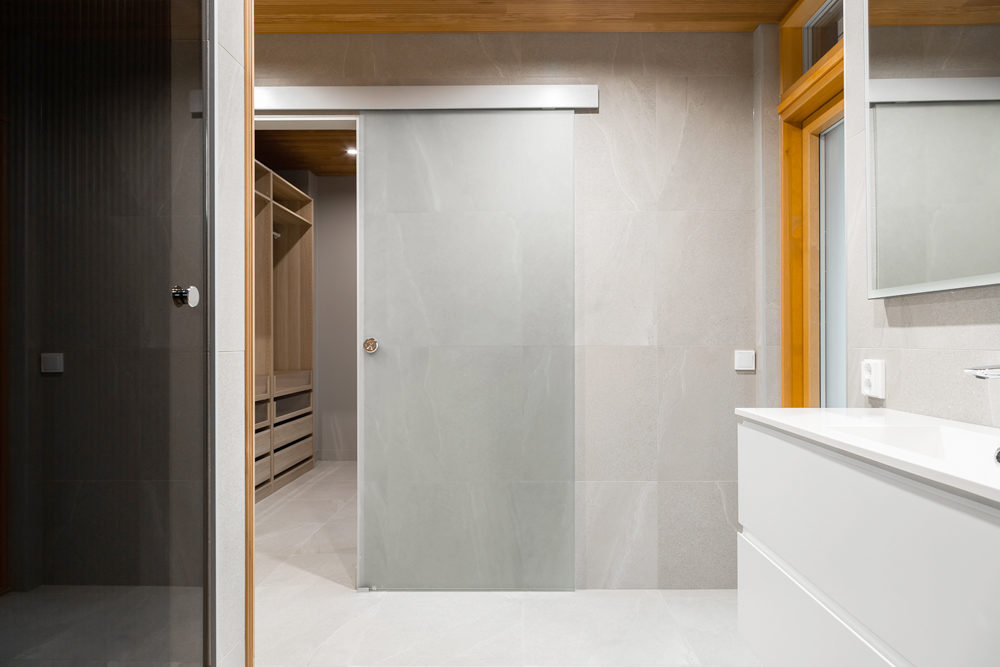 Kylkyhuone: Lasiliukuovi erottaa kylpyhuoneen ja vaatehuoneen.