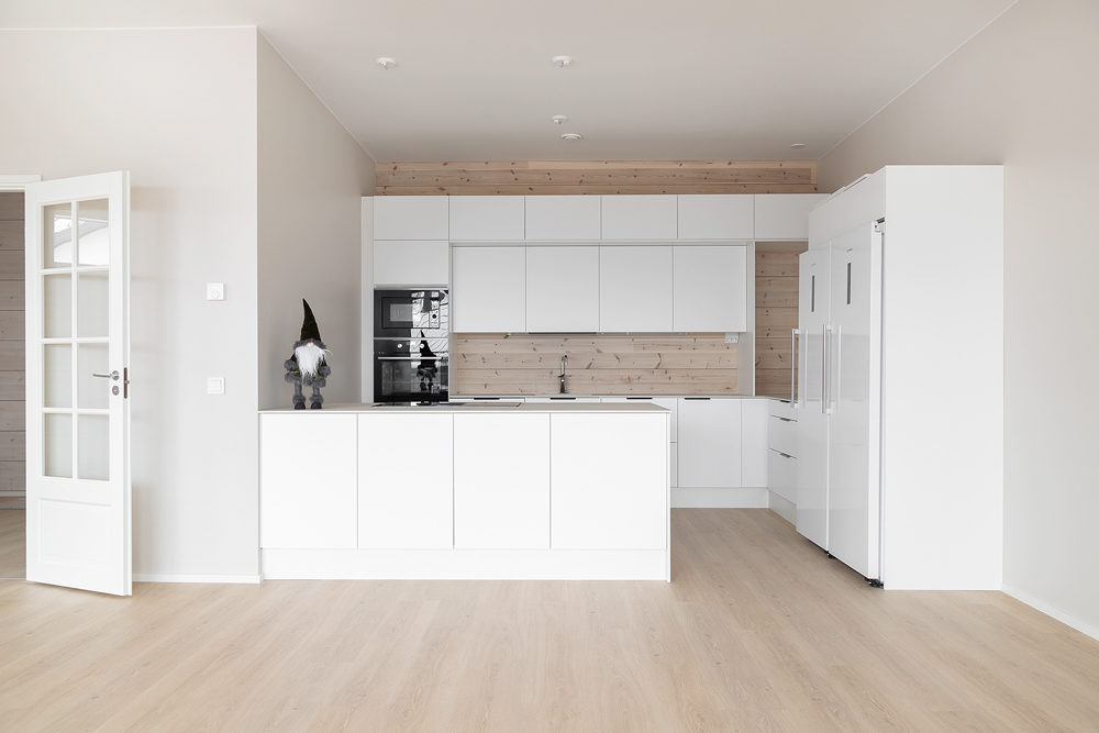 Moderni hirsitalo: Yläkerrassa keittiö kätkeytyy valkoisiin seiniin.