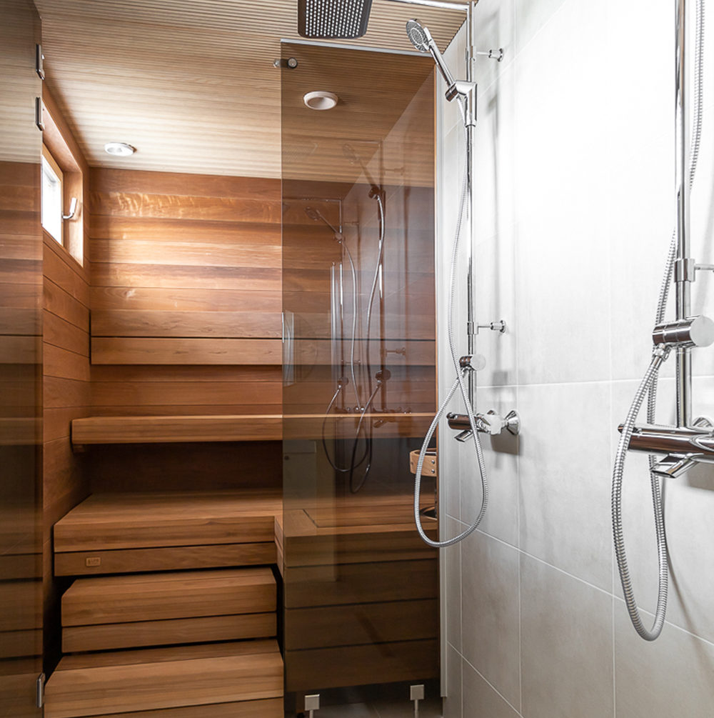 Omakotitalon harmoninen värimaailma toistuu kylpyhuoneessa ja saunassa.