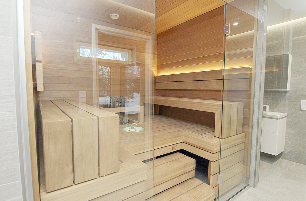 Yksilöllinen muuttovalmis muuttovalmiskoti: Lasiseinä erottaa saunan kylpyhuoneesta.