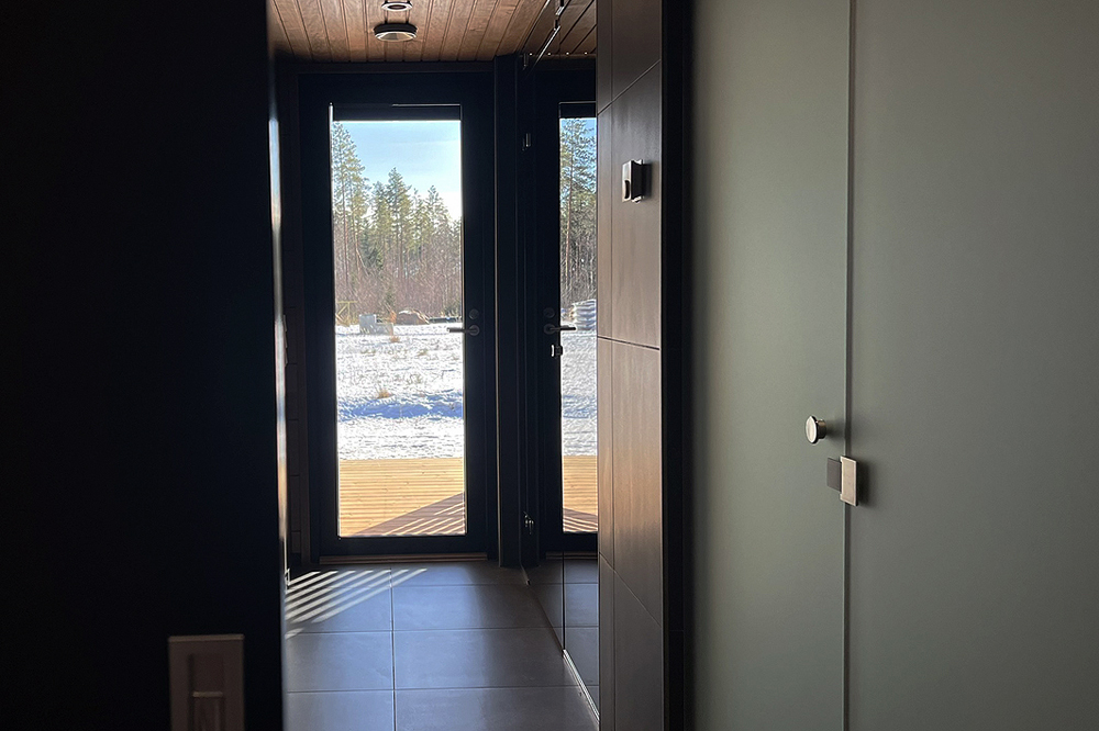 Tumma pukuhuone johdattaa saunaan.